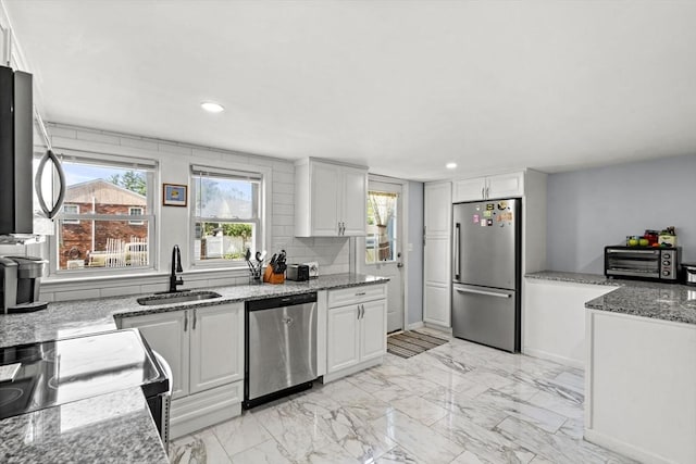 20 King St, Wilmington, MA 01887 - kitchen featuring appliances with stainless steel finishes, white cabinetry, light stone countertops, and recessed lighting