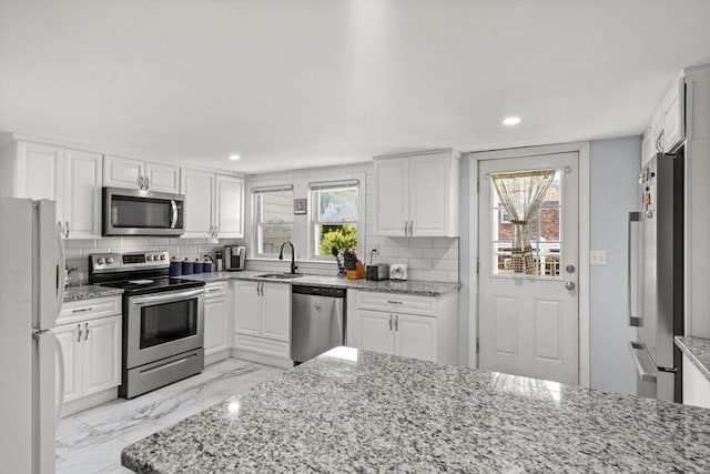 20 King St, Wilmington, MA 01887 - kitchen featuring appliances with stainless steel finishes, light marble finish flooring, white cabinets, and recessed lighting