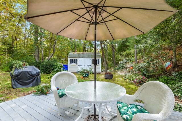 wooden deck featuring area for grilling and a storage shed