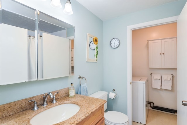 bathroom featuring toilet, vanity, and washer / dryer