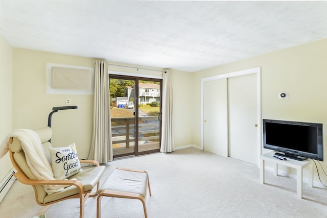 living area featuring light carpet and a baseboard heating unit