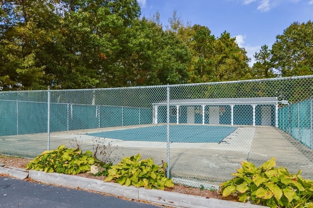 view of swimming pool featuring tennis court