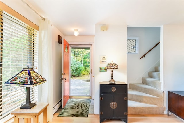 doorway to outside featuring a baseboard heating unit and hardwood / wood-style flooring