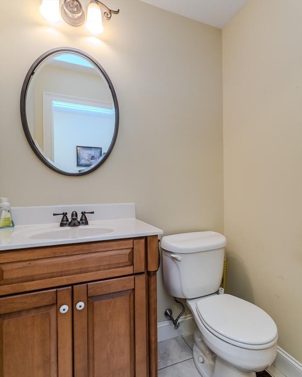 bathroom featuring tile patterned floors, vanity, and toilet