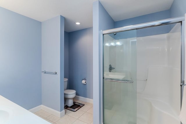 bathroom featuring tile patterned flooring, vanity, toilet, and a shower with door