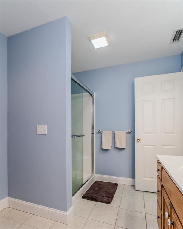 bathroom featuring tile patterned flooring, vanity, and a shower with shower door