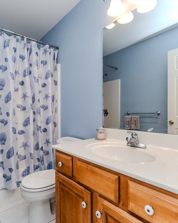 bathroom featuring tile patterned flooring, vanity, curtained shower, and toilet