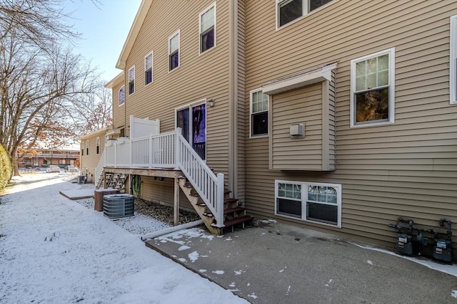 snow covered back of property with central AC unit