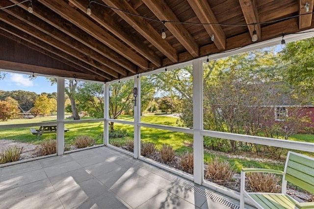 unfurnished sunroom featuring vaulted ceiling