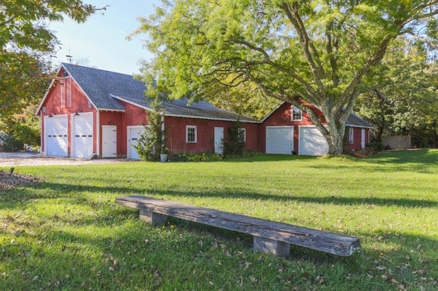 view of front of house featuring a front lawn and an outbuilding