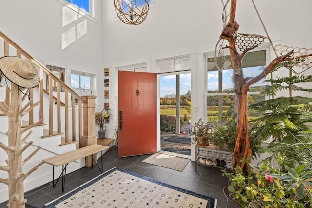 tiled entryway featuring a towering ceiling and plenty of natural light