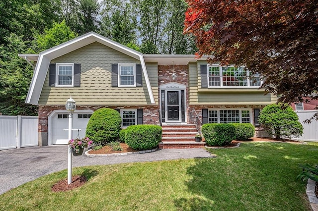 10 Shea Cir, Burlington, MA 01803 - split foyer home with an attached garage, asphalt driveway, and brick siding