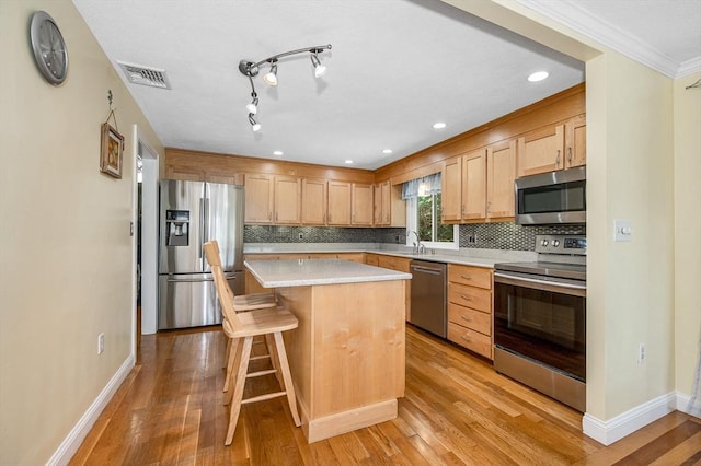 10 Shea Cir, Burlington, MA 01803 - kitchen with appliances with stainless steel finishes, light countertops, backsplash, a kitchen island, and crown molding