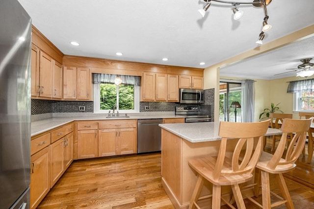 10 Shea Cir, Burlington, MA 01803 - kitchen with appliances with stainless steel finishes, light countertops, light wood-style floors, decorative backsplash, and a kitchen bar