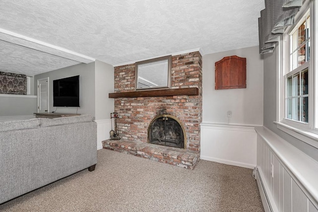 10 Shea Cir, Burlington, MA 01803 - unfurnished living room featuring a textured ceiling, wainscoting, a brick fireplace, carpet flooring, and plenty of natural light