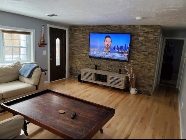 living room with a textured ceiling and light wood-type flooring