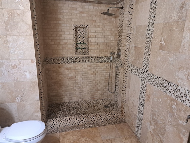 bathroom featuring tiled shower and toilet