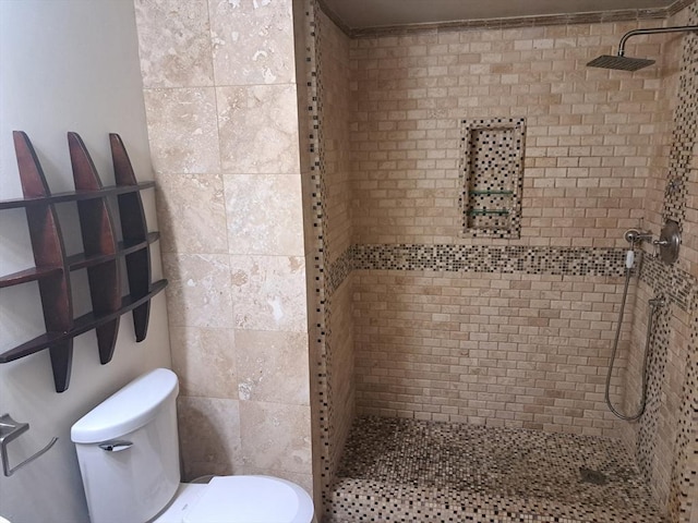 bathroom featuring tiled shower, tile walls, and toilet