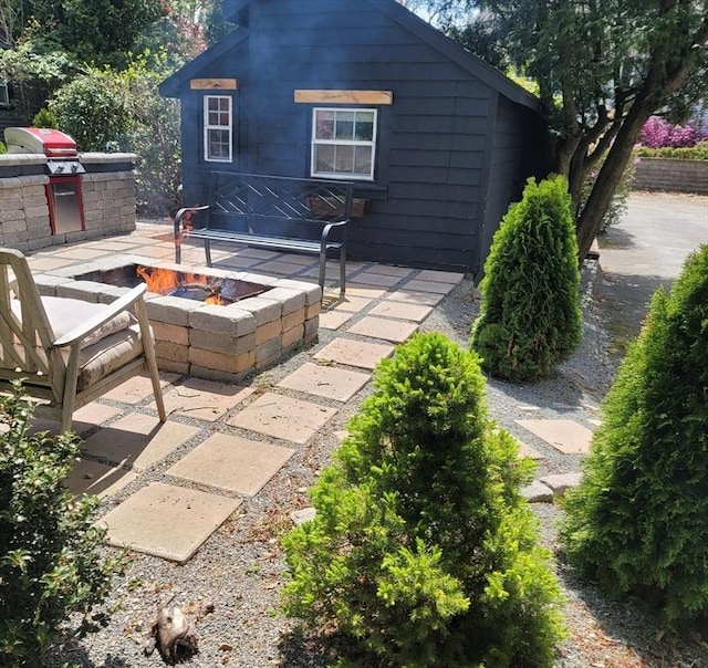 view of patio / terrace featuring area for grilling, a fire pit, and exterior kitchen