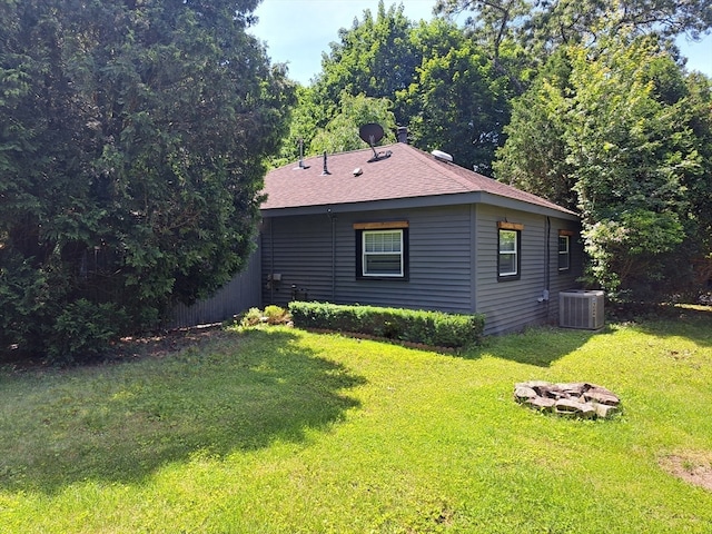 view of property exterior with central AC unit and a lawn