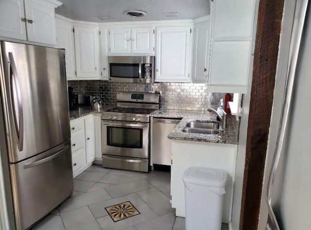 kitchen featuring sink, stone counters, stainless steel appliances, decorative backsplash, and white cabinets