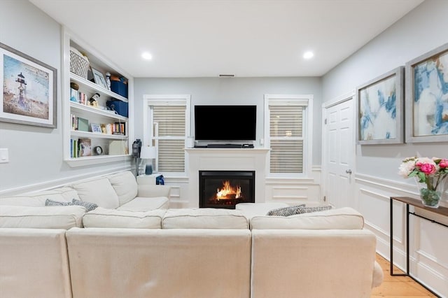 living room featuring light hardwood / wood-style floors and built in features