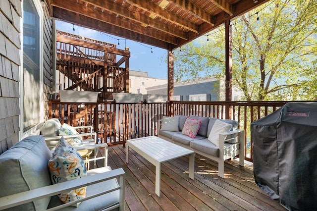 wooden deck with an outdoor hangout area and area for grilling