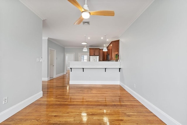 unfurnished living room with crown molding, baseboards, light wood-style floors, and a ceiling fan
