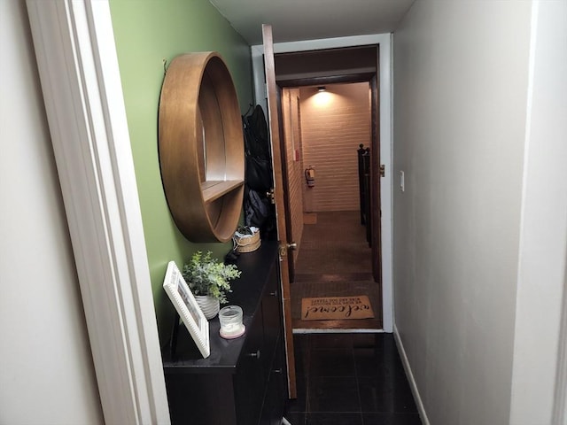 doorway featuring tile patterned floors and baseboards