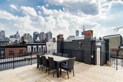 wooden terrace with a skyline view and outdoor dining space