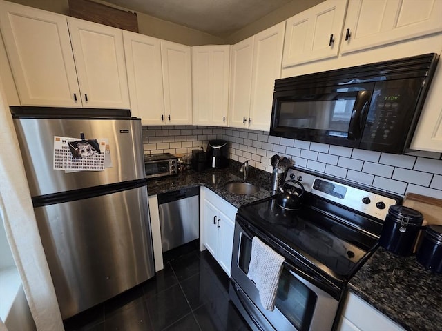kitchen featuring appliances with stainless steel finishes, a sink, backsplash, and white cabinetry