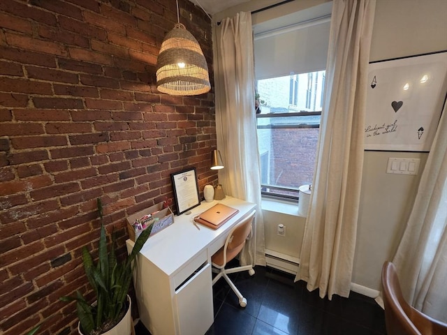 home office featuring dark tile patterned floors, brick wall, and a baseboard heating unit
