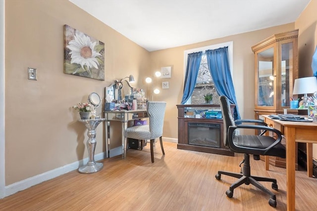 home office with baseboards and wood finished floors