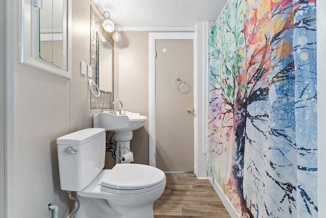 full bathroom featuring a shower with shower curtain, toilet, baseboards, and wood finished floors