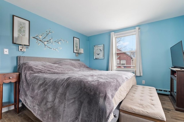 bedroom featuring a baseboard heating unit and wood finished floors