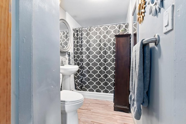 full bathroom featuring a shower with shower curtain, wood finished floors, and toilet