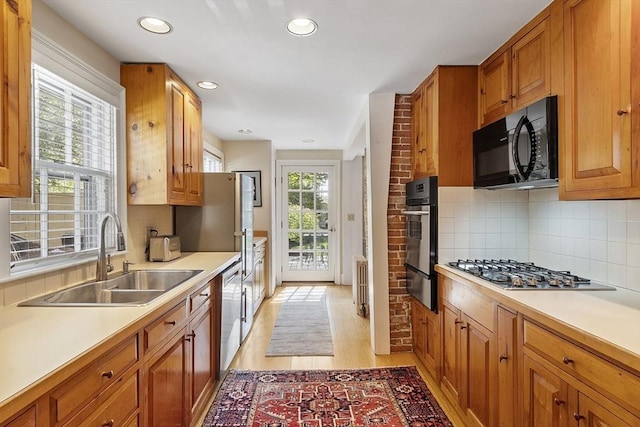 20 Andrew St, Salem, MA 01970 - kitchen with stainless steel appliances, a sink, a warming drawer, light wood-style floors, and light countertops