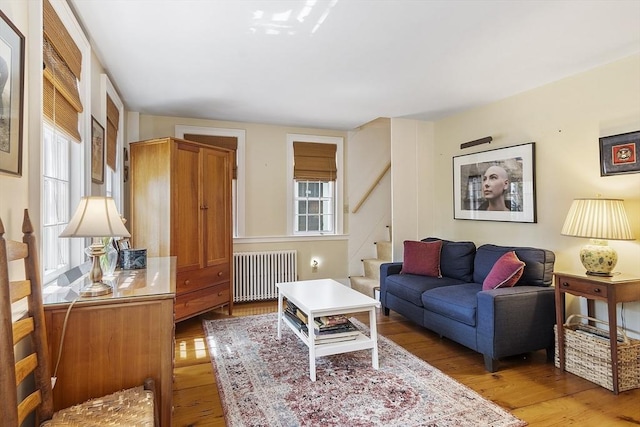 20 Andrew St, Salem, MA 01970 - living area with light wood-type flooring, stairway, and radiator heating unit