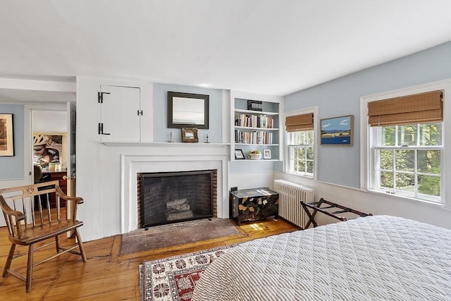 20 Andrew St, Salem, MA 01970 - bedroom with radiator, a fireplace with raised hearth, and hardwood / wood-style flooring