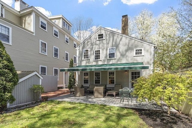 20 Andrew St, Salem, MA 01970 - back of house with a chimney, a patio, outdoor lounge area, and a lawn