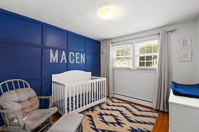42 Mary Anne Ave, Brockton, MA 02302 - bedroom with a baseboard radiator, wood finished floors, and a nursery area