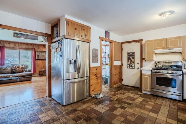 kitchen with backsplash, stainless steel appliances, and wood walls