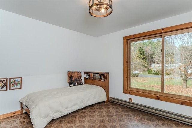 bedroom with multiple windows and a baseboard heating unit