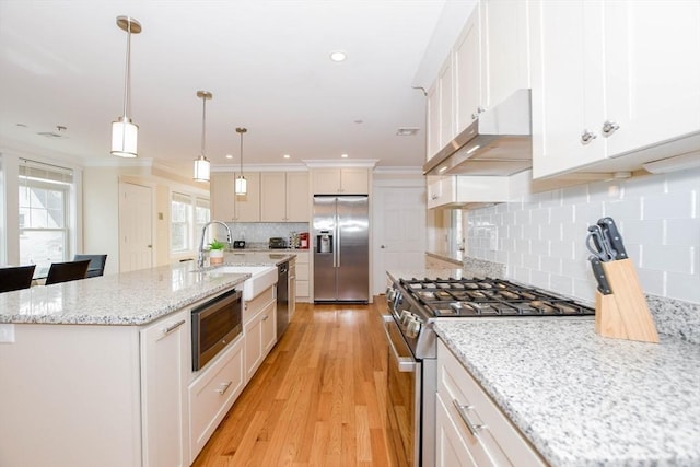 kitchen featuring white cabinetry, a kitchen island with sink, appliances with stainless steel finishes, and a sink