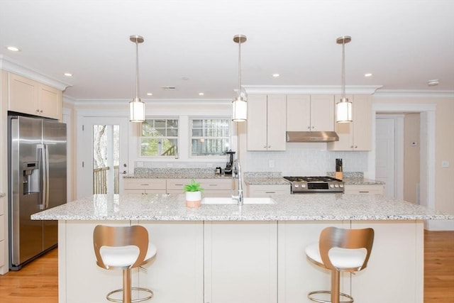 kitchen featuring a center island with sink, pendant lighting, and stainless steel appliances