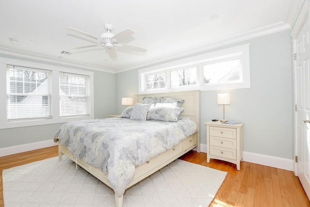 bedroom featuring light wood-style floors, visible vents, crown molding, and baseboards