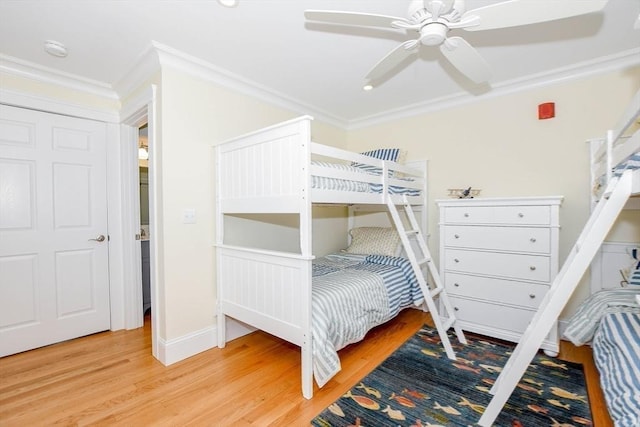 bedroom featuring baseboards, wood finished floors, a ceiling fan, and crown molding