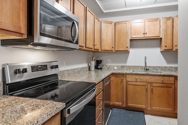 46 Ashford Unit 14, Methuen, MA 01844 - kitchen featuring stainless steel appliances, light stone countertops, and brown cabinetry
