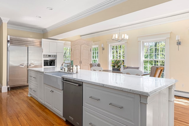 kitchen with stainless steel appliances, hanging light fixtures, light hardwood / wood-style floors, and a kitchen island