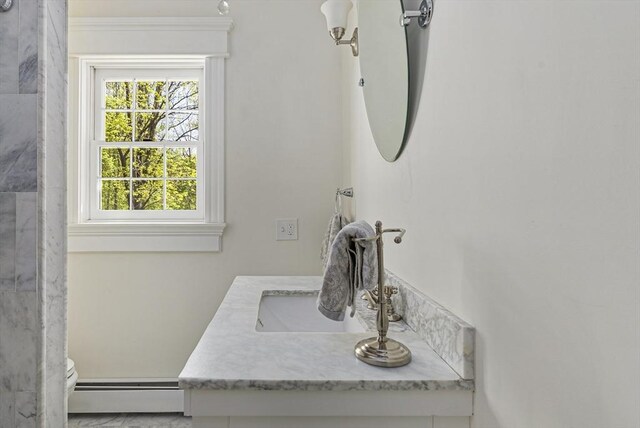 bathroom with a baseboard heating unit, toilet, and vanity